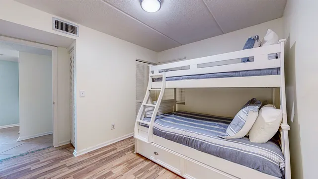 a bedroom with a bed and wooden floor