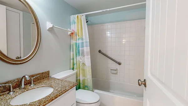 a bathroom with a granite countertop sink toilet and shower