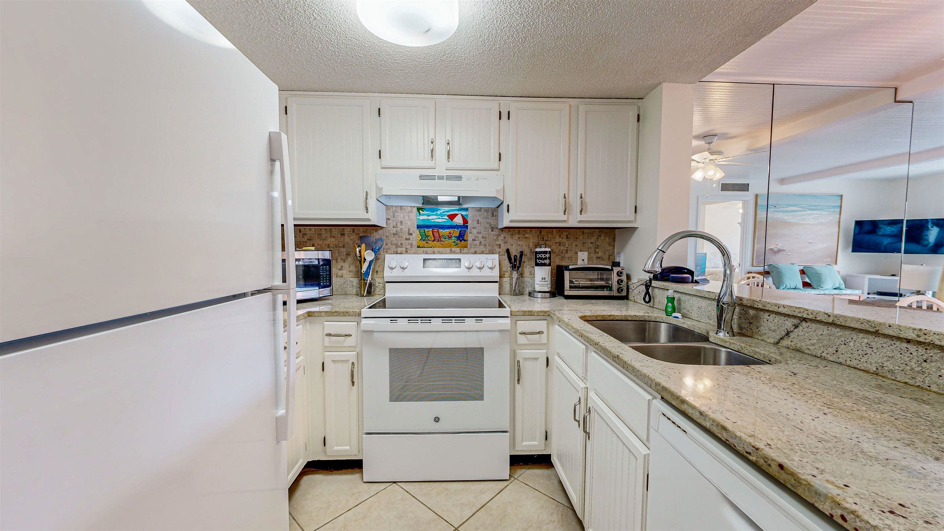 880 A1A Beach Boulevard, Unit 3207 St. Augustine, FL 32080 - Photo 7 of 33 a kitchen with white cabinets sink and white appliances