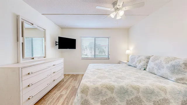 a bedroom with a large bed and a flat tv screen on dresser