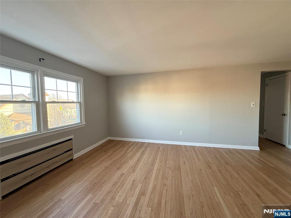 175 Van Winkle Street, Unit 2 East Rutherford, NJ 07073 - Photo 8 of 20 an empty room with wooden floor and windows