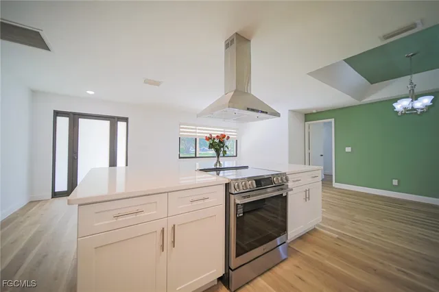 a kitchen with stainless steel appliances granite countertop a stove a sink and a wooden floors