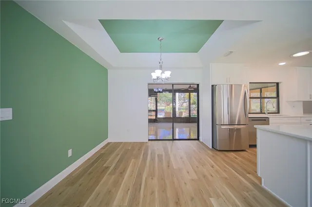 a kitchen with stainless steel appliances white cabinets and wooden floor