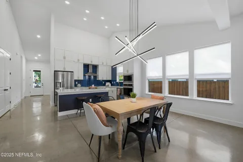 a kitchen with stainless steel appliances a table and chairs in it