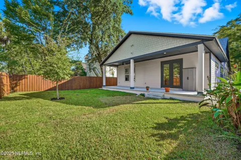 a backyard of a house with plants and a tree