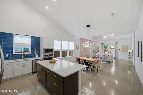 a kitchen with refrigerator and chairs