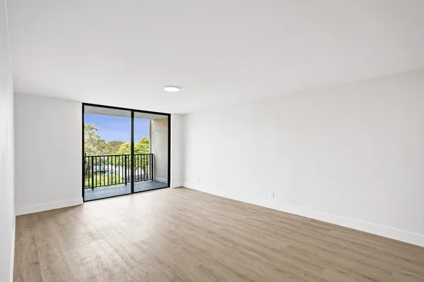 an empty room with wooden floor and sliding door