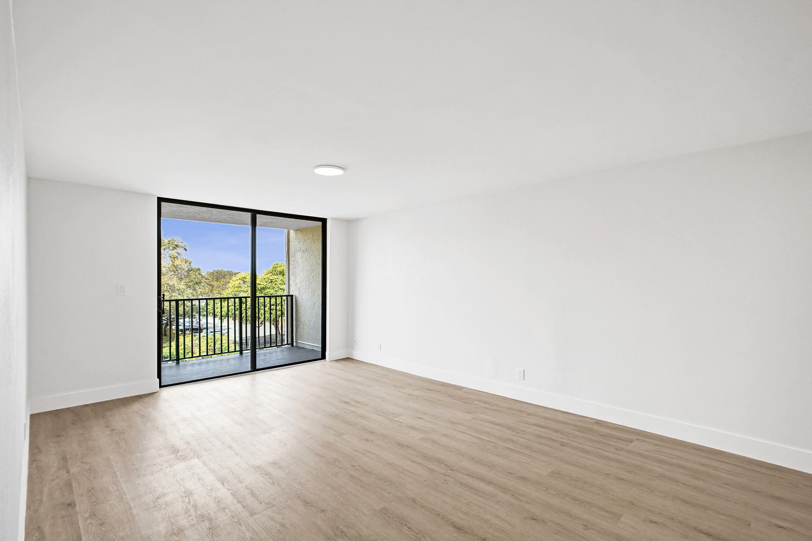 6195 Rock Island Road, Unit 413 Tamarac, FL 33319 - Photo 12 of 37 an empty room with wooden floor and sliding door