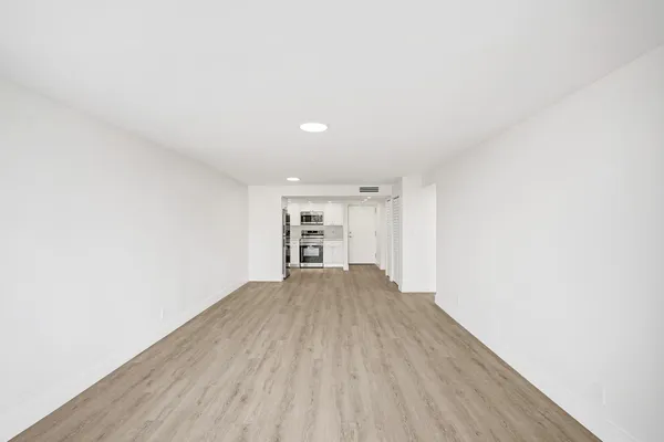 a view of empty room with wooden floor
