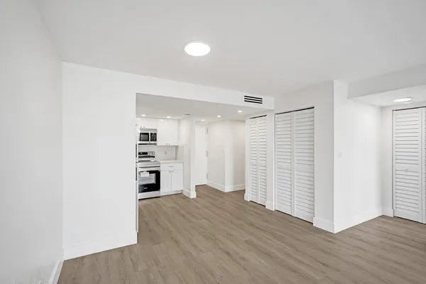 a view of empty room with wooden floor