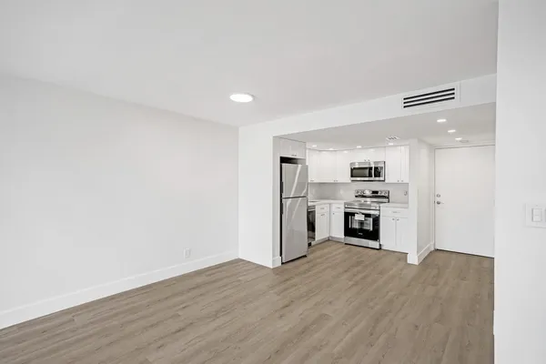 a view of kitchen with wooden floor and electronic appliances