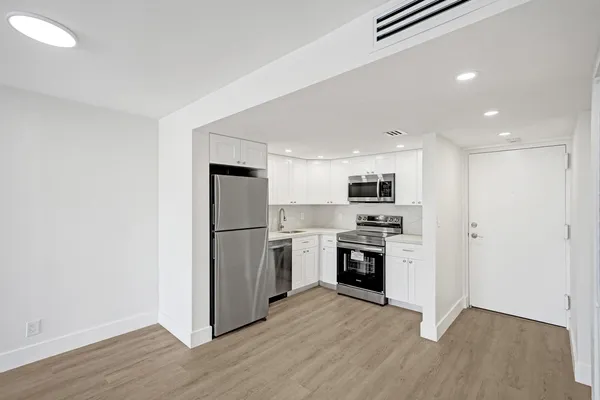 a kitchen with a refrigerator a stove top oven and kitchen island