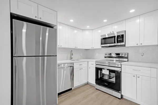 a kitchen with stainless steel appliances granite countertop a stove a refrigerator and a microwave