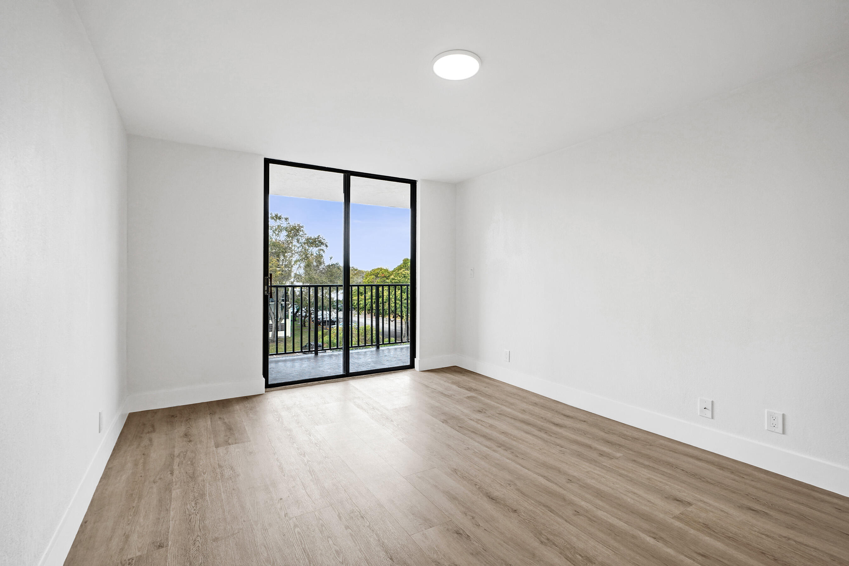 6195 Rock Island Road, Unit 413 Tamarac, FL 33319 - Photo 23 of 37 a view of an empty room with wooden floor and a window