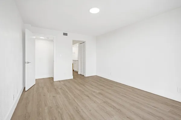 a view of an empty room with wooden floor