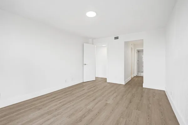 a view of an empty room with wooden floor
