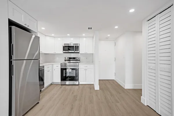 a kitchen with a refrigerator a stove and a sink