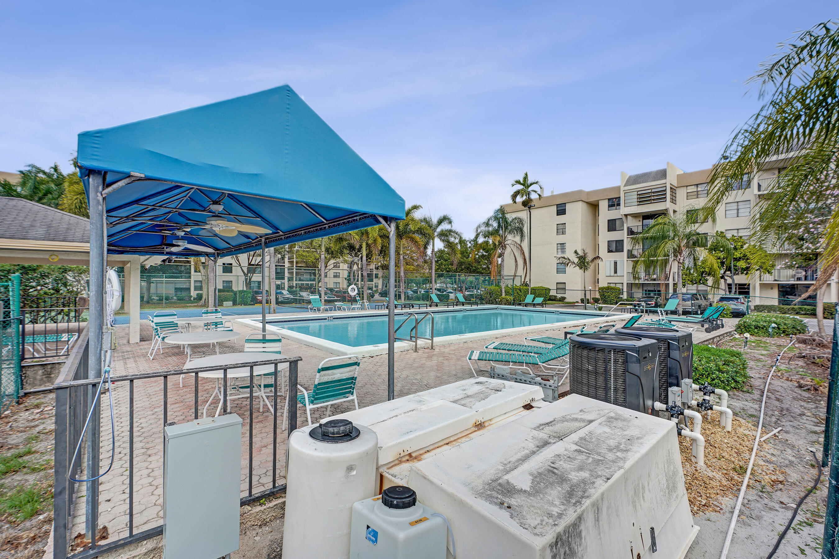 6195 Rock Island Road, Unit 413 Tamarac, FL 33319 - Photo 32 of 37 a view of a patio with table and chairs under an umbrella