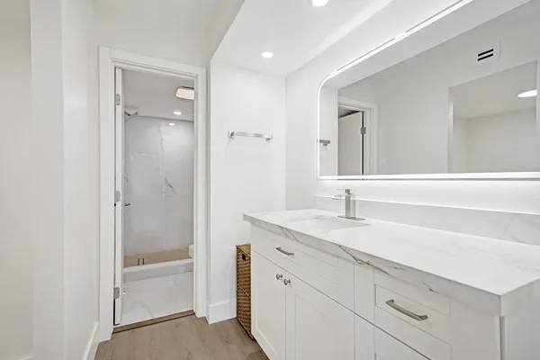 a bathroom with a granite countertop sink a mirror and a bathtub