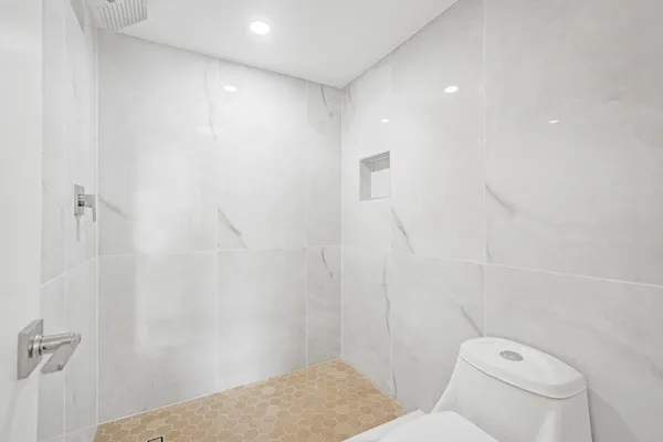 a bathroom with a toilet and a shower