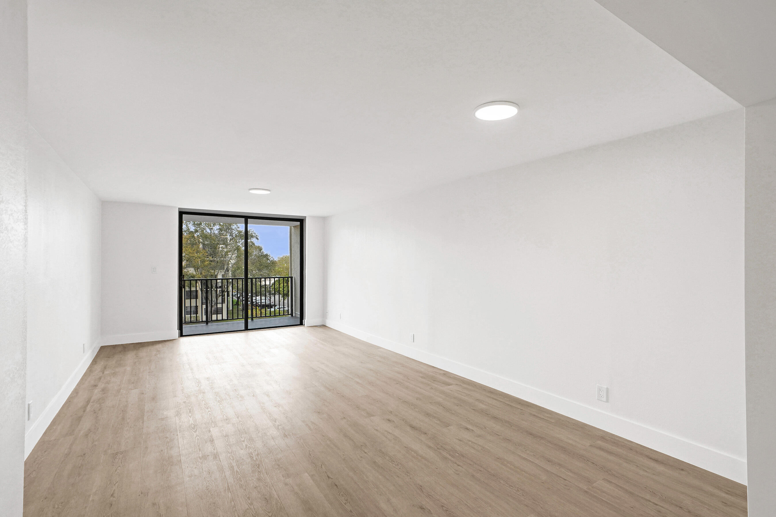 6195 Rock Island Road, Unit 413 Tamarac, FL 33319 - Photo 10 of 37 an empty room with wooden floor and windows