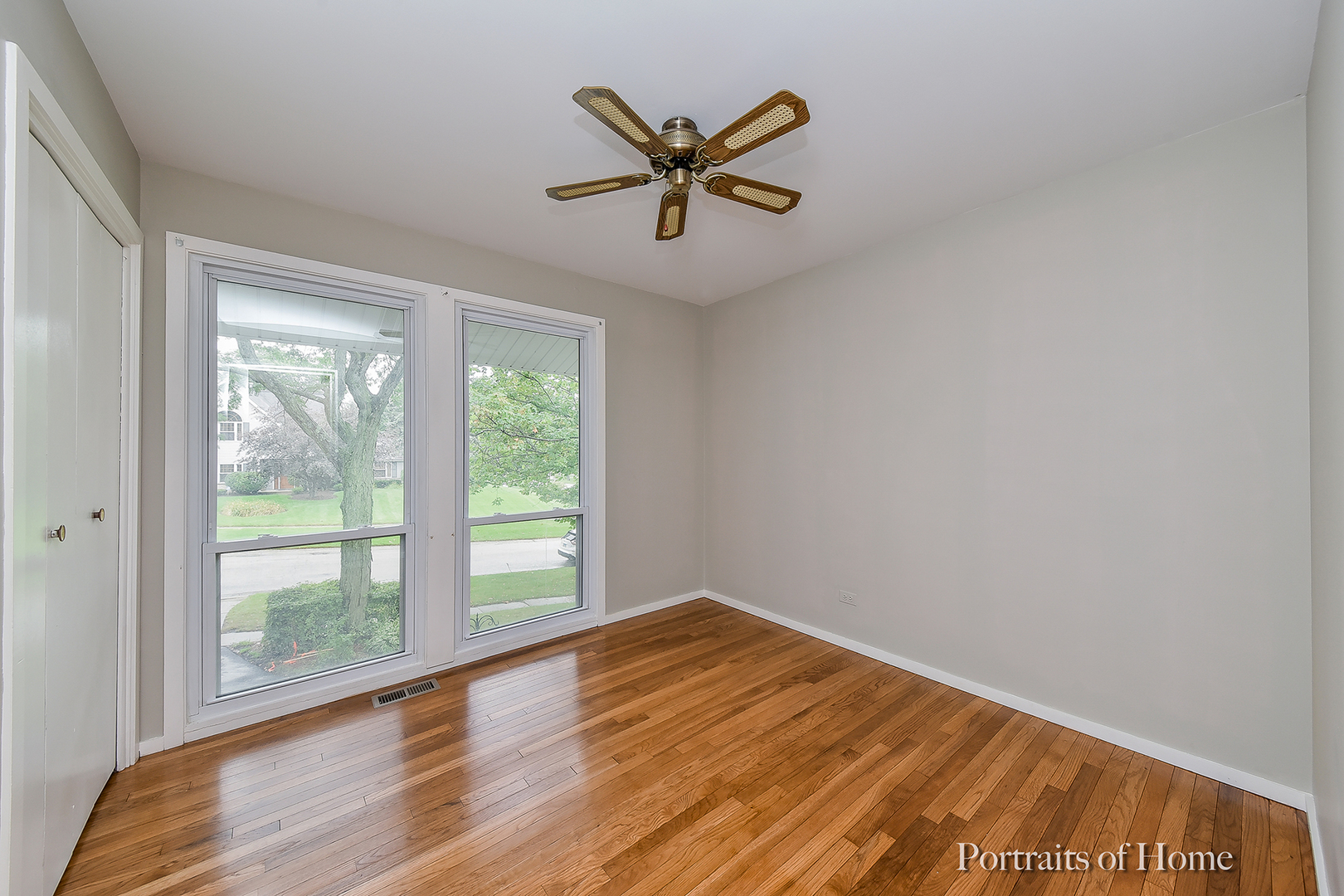 2S645 Bob O Link Road Lombard, IL 60148 - Photo 4 of 18 a view of a big room with wooden floor a ceiling fan and windows