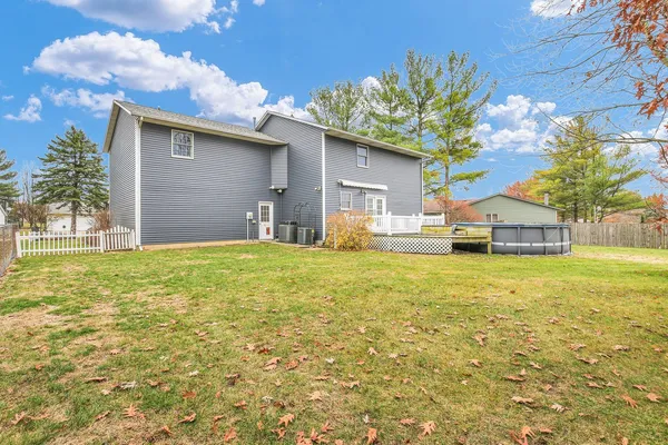 a view of a room with wooden floor chandelier and windows