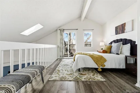 a spacious bedroom with a bed and wooden floor