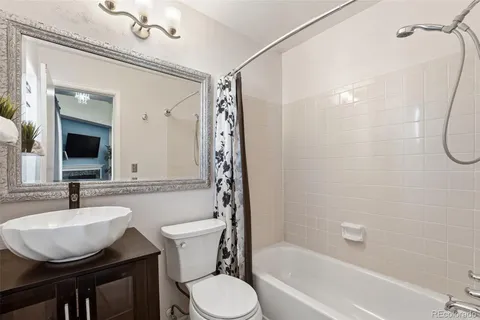 a bathroom with a sink toilet a mirror and shower