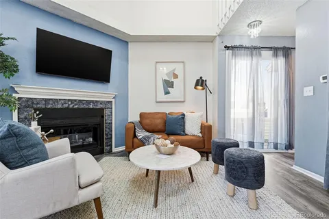a living room with furniture a flat screen tv and a fireplace