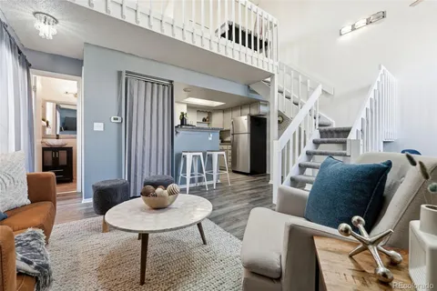 a living room with furniture a rug and kitchen view