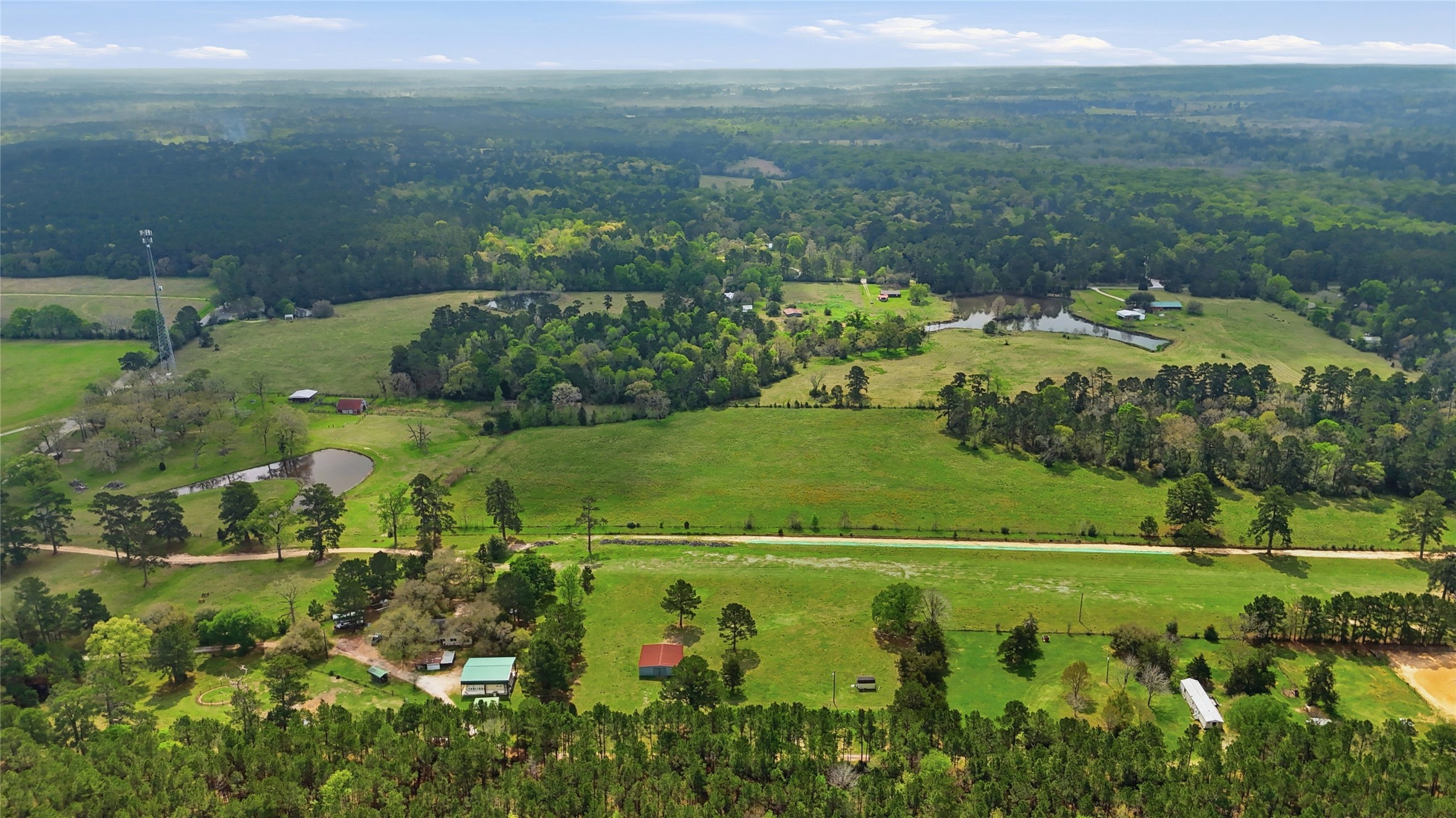 872 Four Notch Road Huntsville, TX 77340 - Photo 31 of 42 Expansive rural landscape with lush greenery, rolling fields, and serene ponds, offering a tranquil setting ideal for country living.