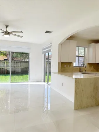 a view of a kitchen with granite countertop a sink and a stove top oven