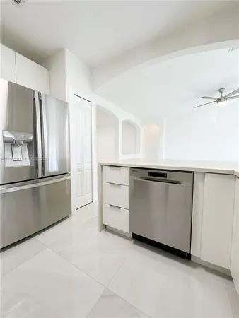 a kitchen with granite countertop a refrigerator and a sink