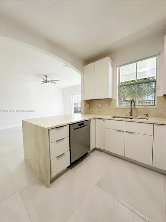 a kitchen with a white stove top oven sink and cabinets