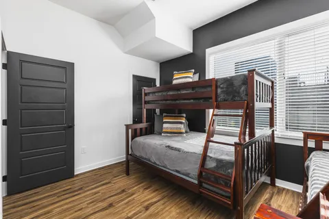 a bedroom with a bed and wooden floor