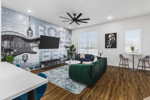 a living room with furniture a rug and a flat screen tv