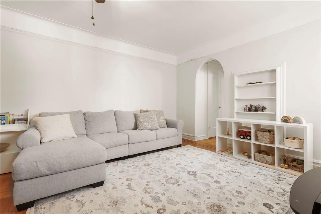 219 Bronx River Road, Unit 6A Yonkers, NY 10704 - Photo 1 of 1 a living room with a couch and a bookshelf