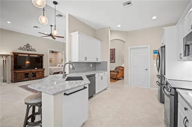 a kitchen with granite countertop a sink appliances and cabinets