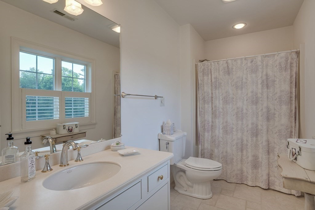 32 Bancroft Road Andover, MA 01810 - Photo 34 of 41 a bathroom with a toilet a sink a mirror and a shower