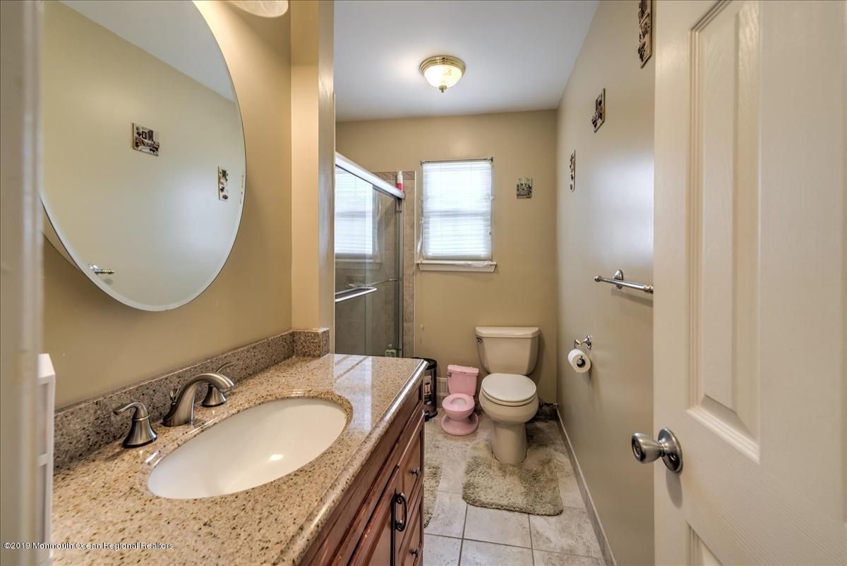 6 Timberline Drive Howell, NJ 07731 - Photo 12 of 12 a bathroom with a granite countertop sink a mirror and a toilet