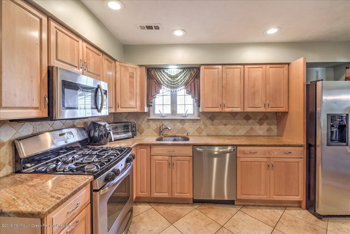 6 Timberline Drive Howell, NJ 07731 - Photo 8 of 12 a kitchen with granite countertop a stove sink and cabinets