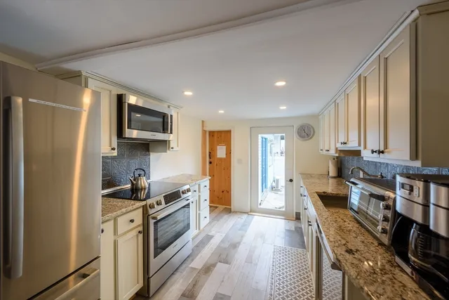 a kitchen with stainless steel appliances granite countertop a refrigerator stove and sink