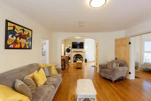 a living room with furniture and a large mirror with wooden floor