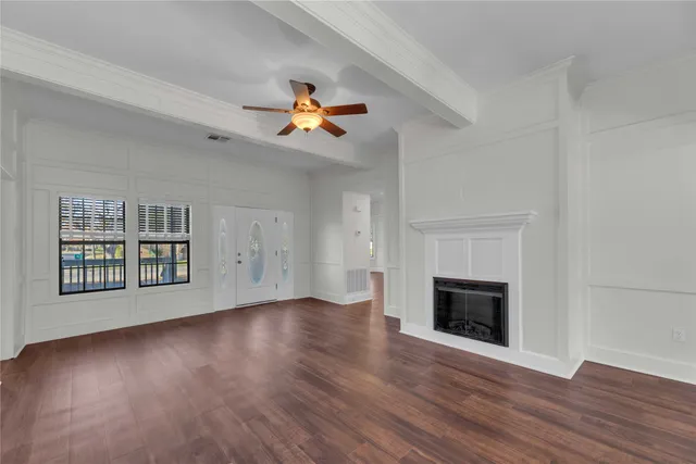 an empty room with windows and fireplace