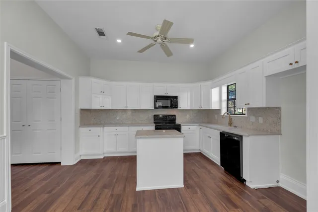 a kitchen with wooden floors and appliances