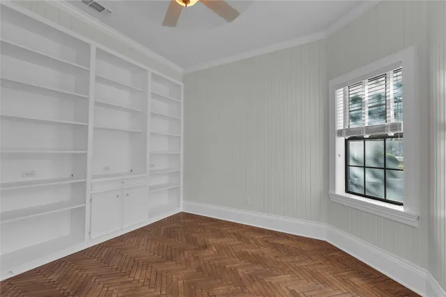 an empty room with windows and cabinet