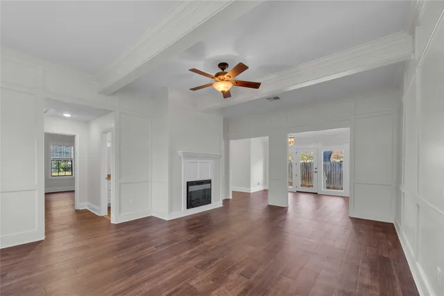 a view of empty room with wooden floor and a ceiling fan