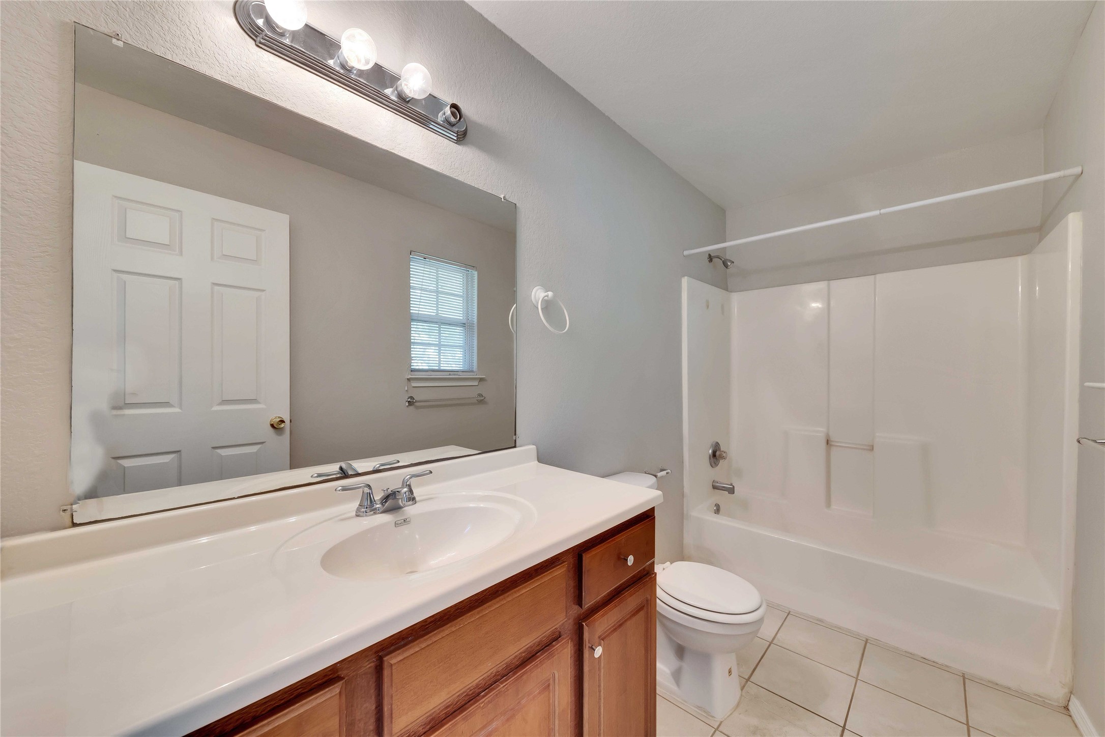 2201 East 18th Street, Unit B Austin, TX 78702 - Photo 15 of 25 A well-lit bathroom features a spacious vanity and a combination shower-tub for daily rejuvenation.