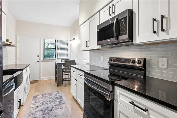 a kitchen with stainless steel appliances a stove microwave and sink